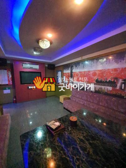 미추홀구 노래방 원문 등록 사진. 화면과 긴 소파, 테이블이 보이는 공간