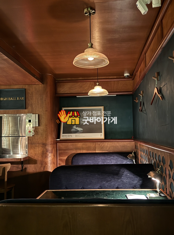 송파구 와인바 원문 등록 사진. 나무 마감, 천장 조명과 벽면 좌석이 보이는 내부
